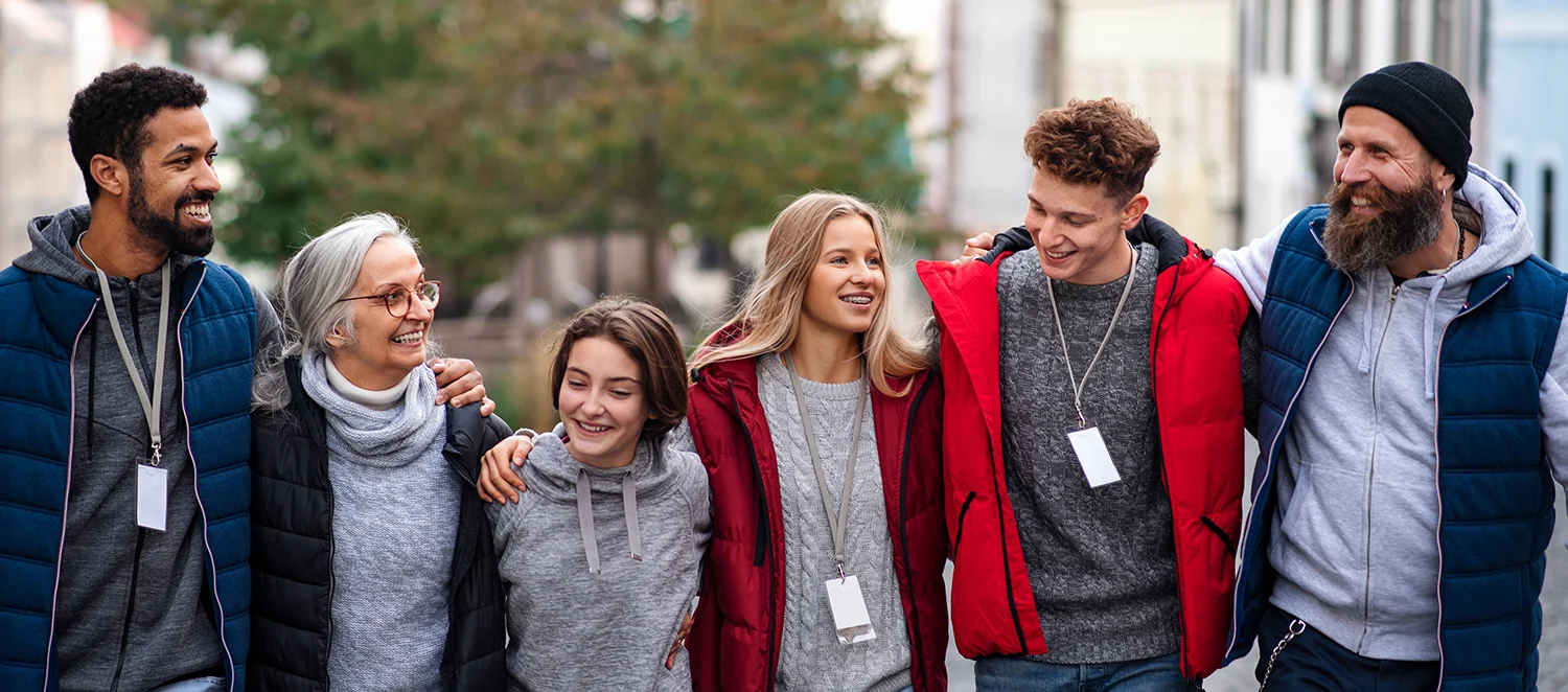 Eine Gruppe Freiwilliger, die gemeinsam Arm in Arm spazieren gehen.